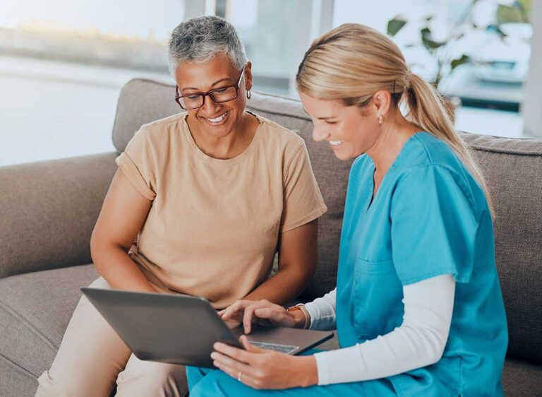 Two older adults and a younger family member sitting at a table, reviewing paperwork together in a bright living space.